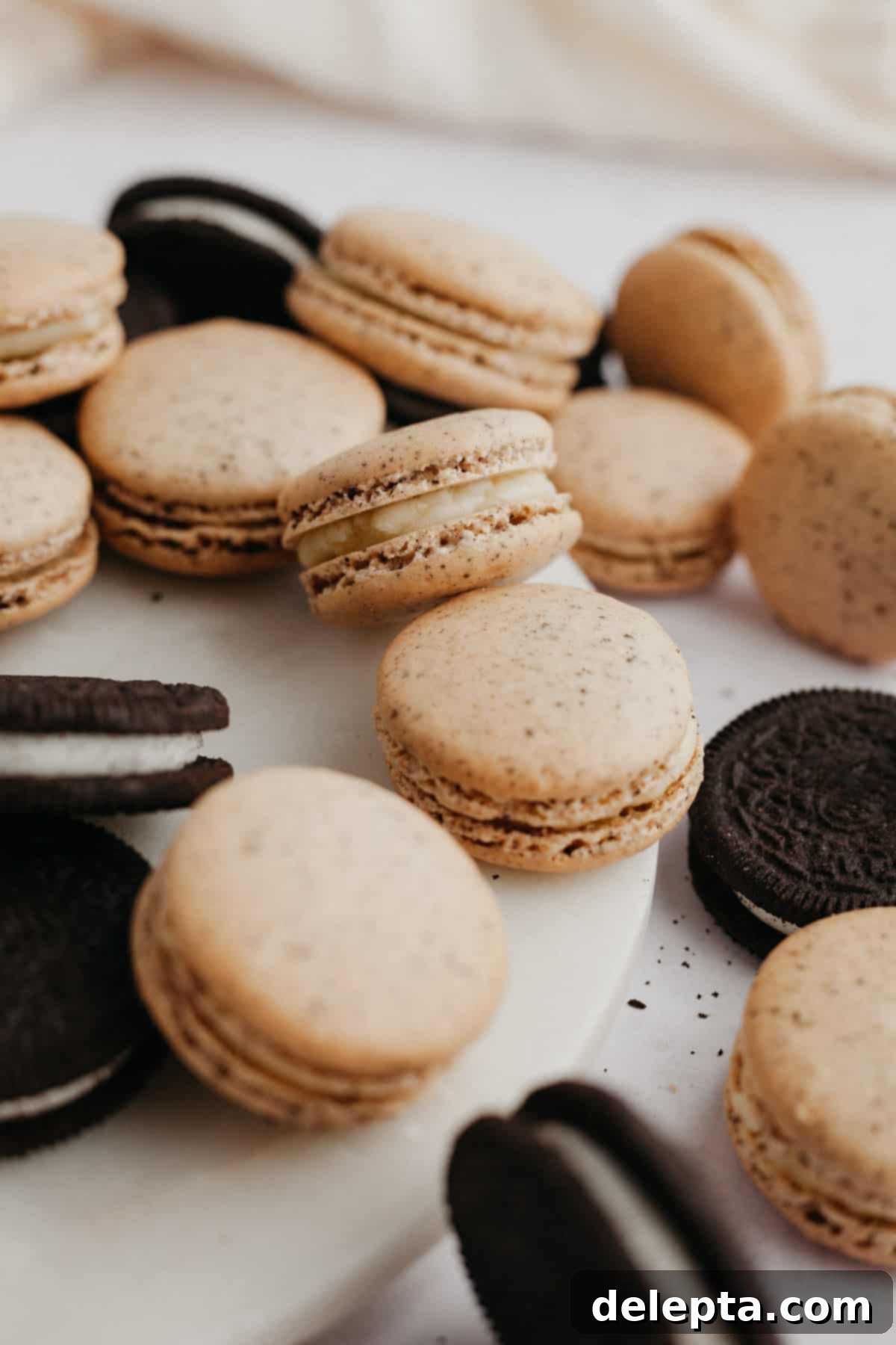 Cookies & Cream Macarons 12 A beautiful display of finished cookies and cream macarons alongside original Oreo cookies, highlighting the inspiration and delicious outcome.