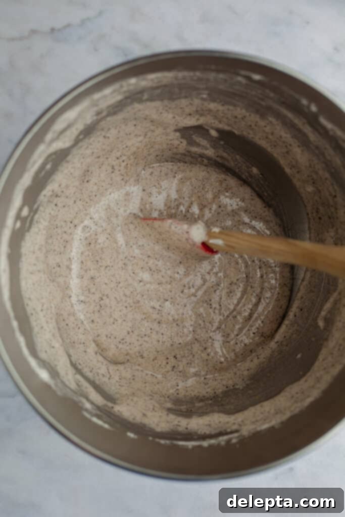 Cookies & Cream Macarons 8 A smooth and shiny cookies and cream macaron batter, perfectly mixed and ready for piping, inside a silver mixing bowl.