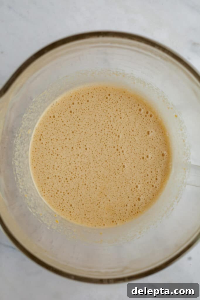 Fudgy Brownie Pie 14 The beautifully whipped eggs and sugars in a glass bowl, now transformed into a pale, voluminous, and frothy mixture, indicative of proper aeration vital for developing the desired crackly brownie top.