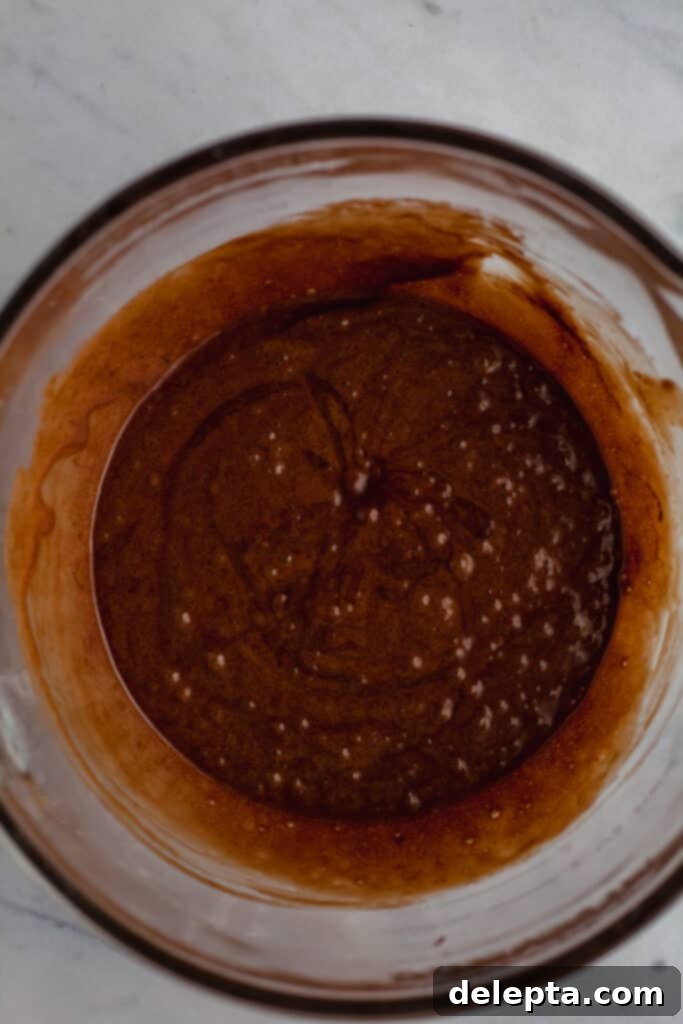 Fudgy Brownie Pie 15 A rich, smooth, and glossy brownie batter perfectly mixed in a glass bowl, showcasing its readiness to be poured into the prepared crust and baked into a decadent treat.