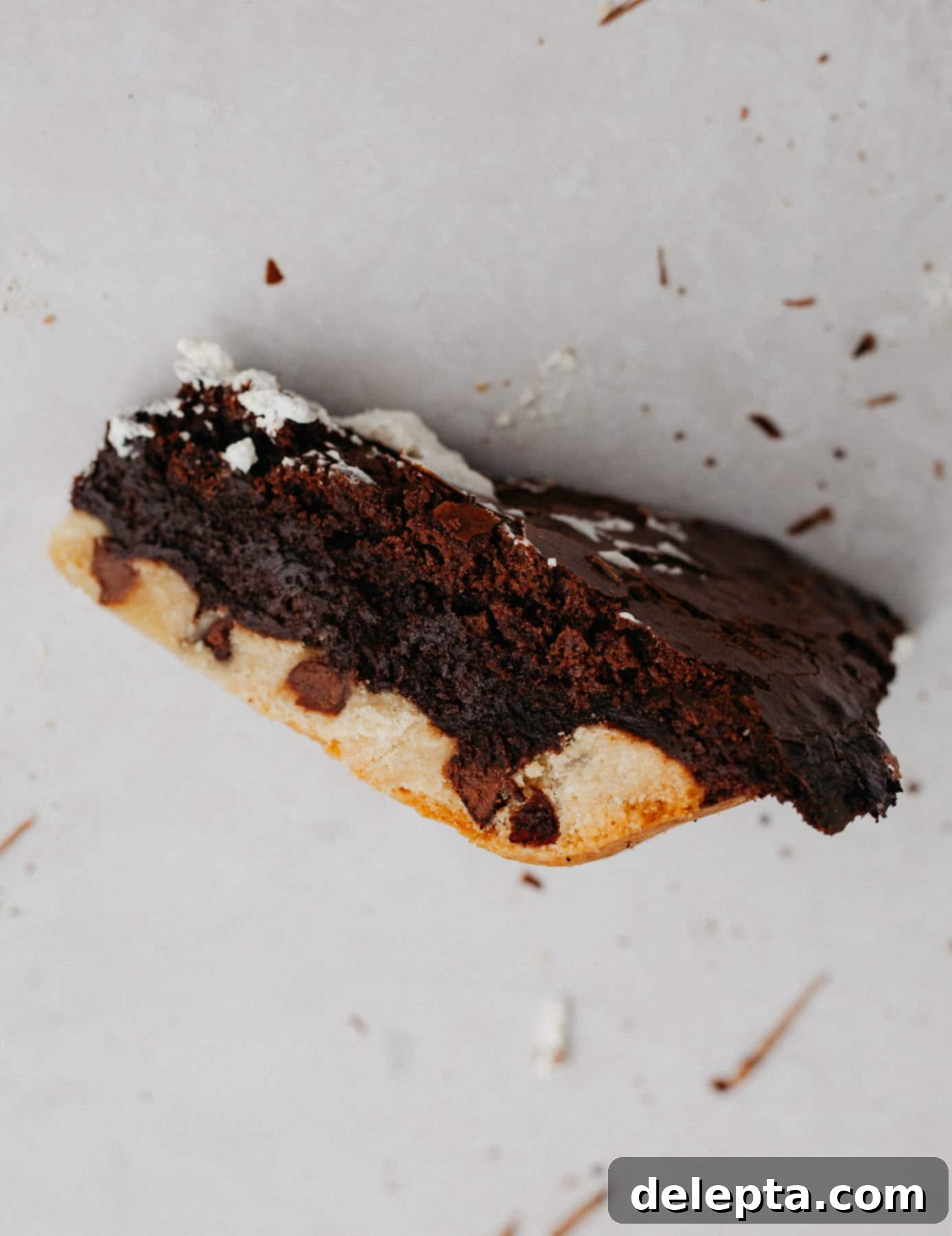 Fudgy Brownie Pie 17 A perfectly baked slice of brookie pie presented on its side, revealing the distinct layers of rich, fudgy brownie and chewy chocolate chip cookie crust.