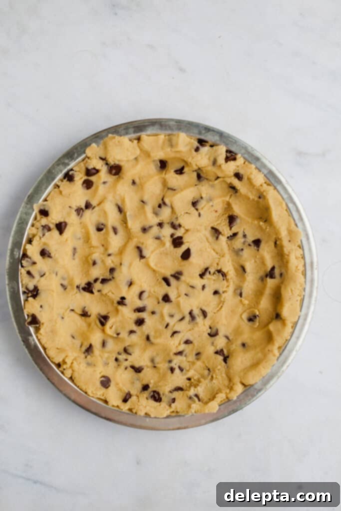 Fudgy Brownie Pie 10 The chocolate chip cookie dough meticulously pressed evenly into a 9-inch pie plate, forming a smooth and uniform layer, perfectly ready for its chilling and subsequent baking stages.