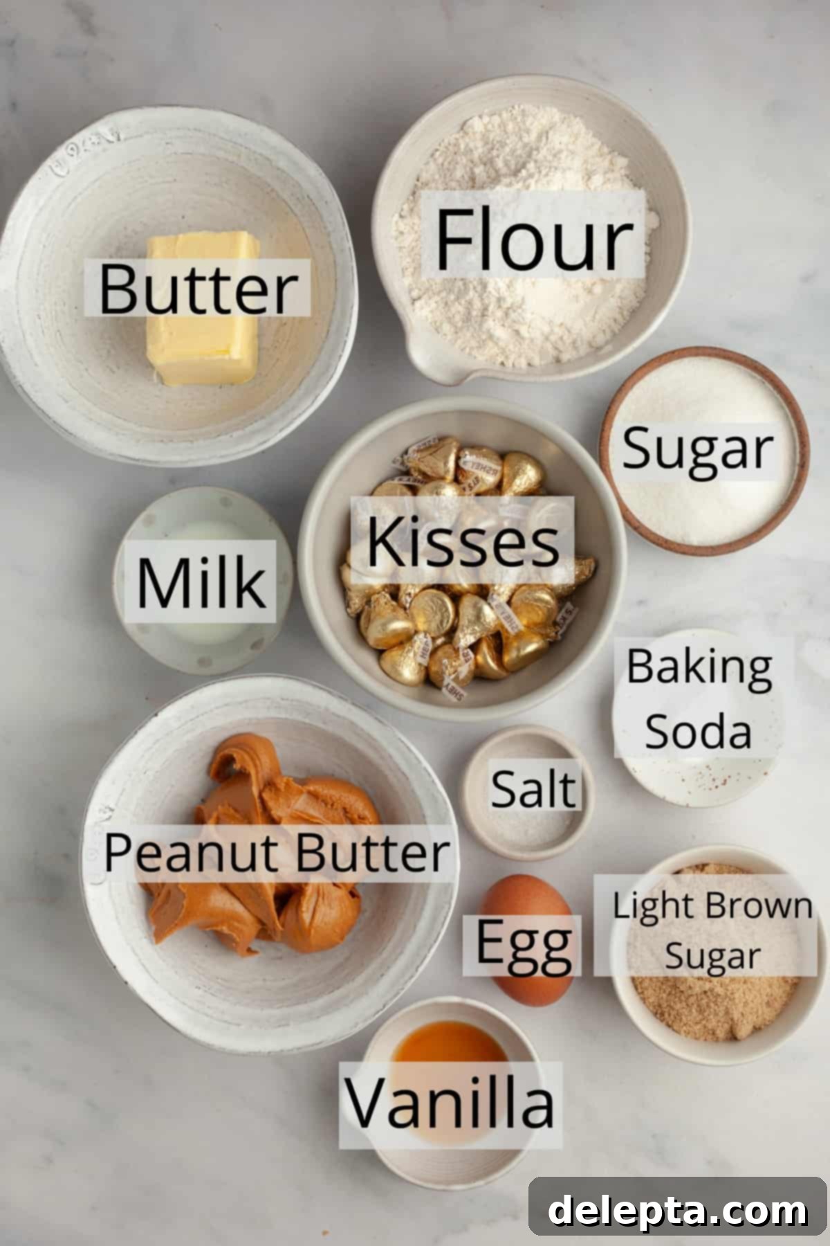 Beloved Hershey's Kiss Thumbprint Cookies 3 All the necessary ingredients for baking peanut butter blossoms, meticulously weighed and arranged in small bowls on a wooden surface.
