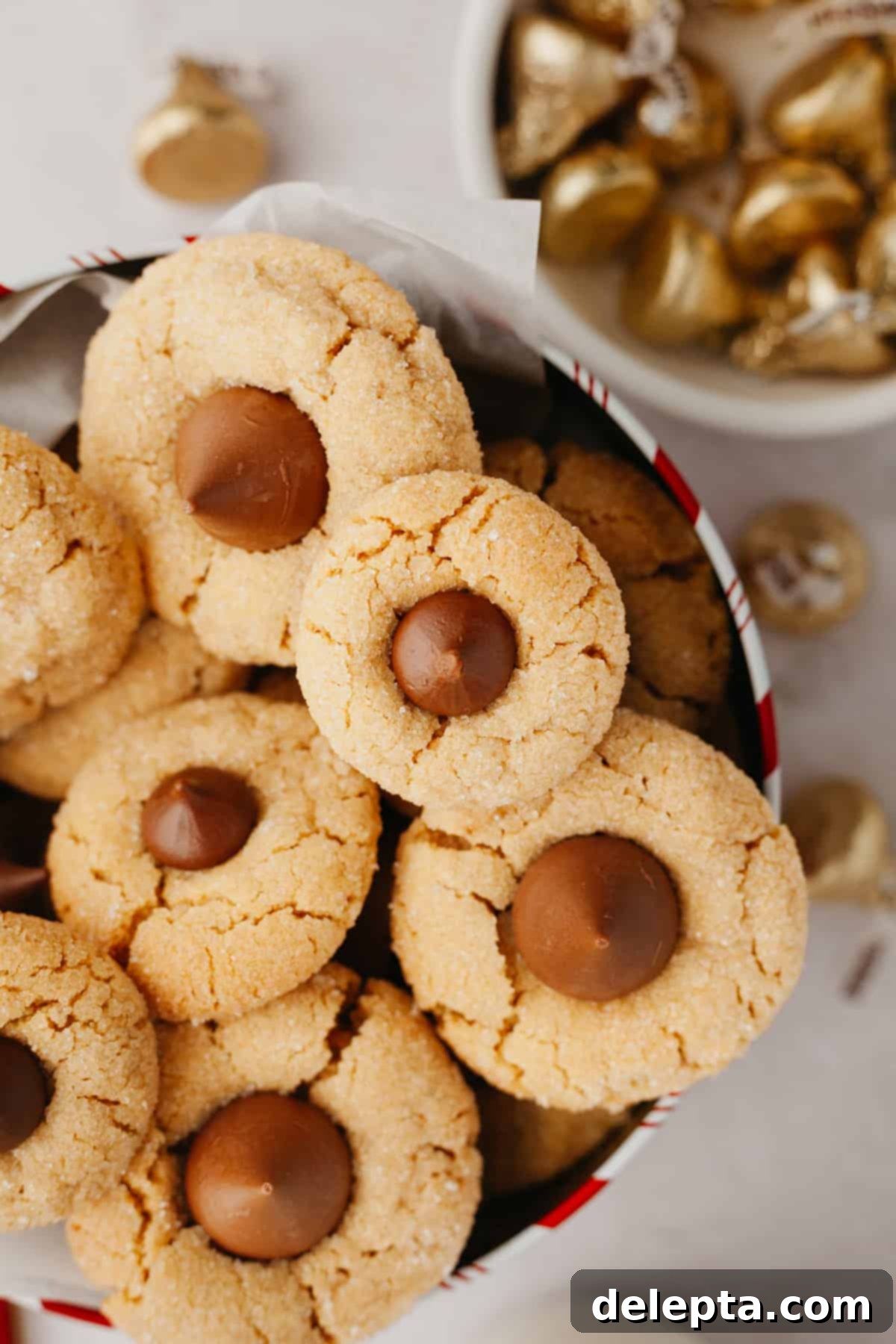 Beloved Hershey's Kiss Thumbprint Cookies 6 Several soft peanut butter thumbprint cookies, each topped with a delicate Hershey's Kiss, arranged beautifully in a decorative tin.