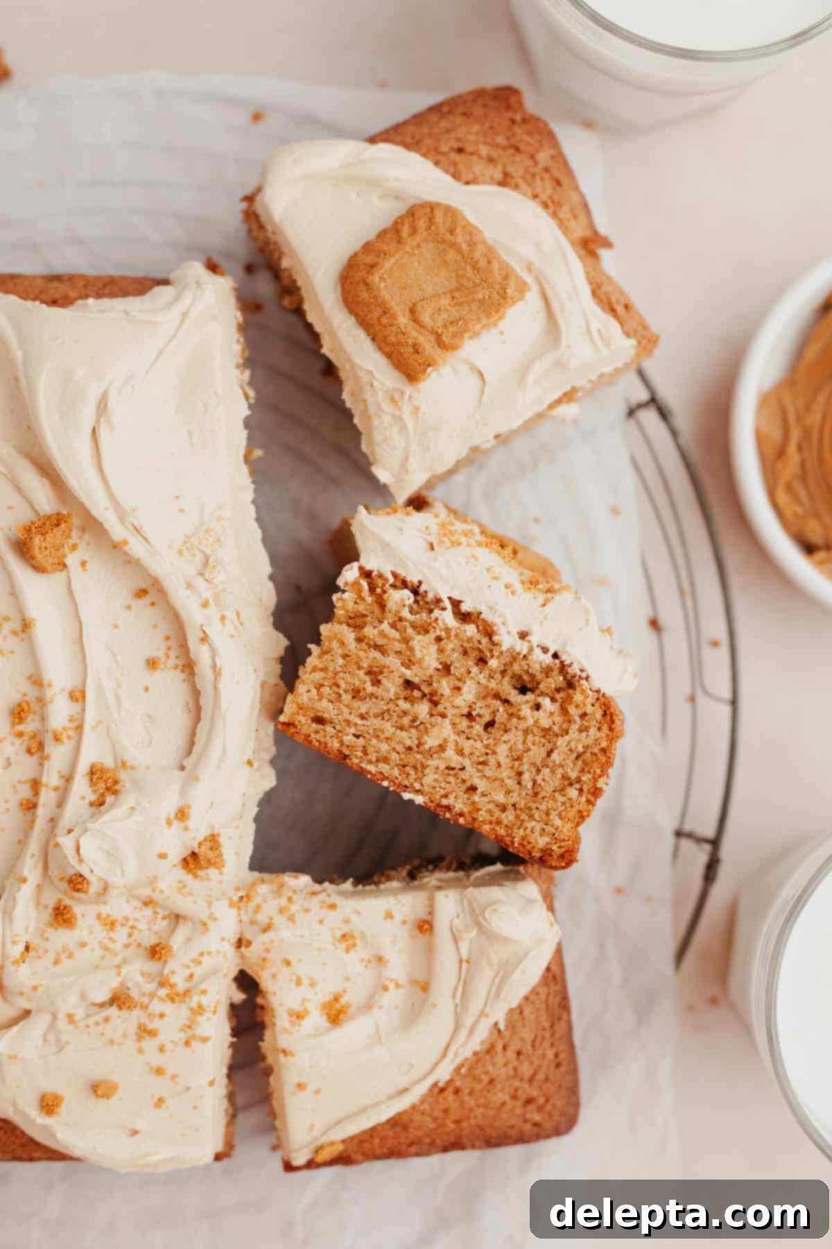 Effortless Lotus Biscoff Cake 8 An overhead shot of a sheet cake covered in beige frosting and topped with Biscoff cookies.
