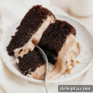 Decadent Nutella Delight 10 A slice of our decadent Nutella filled chocolate cake, perfectly showcasing its moist layers and rich frosting on a charming small plate.