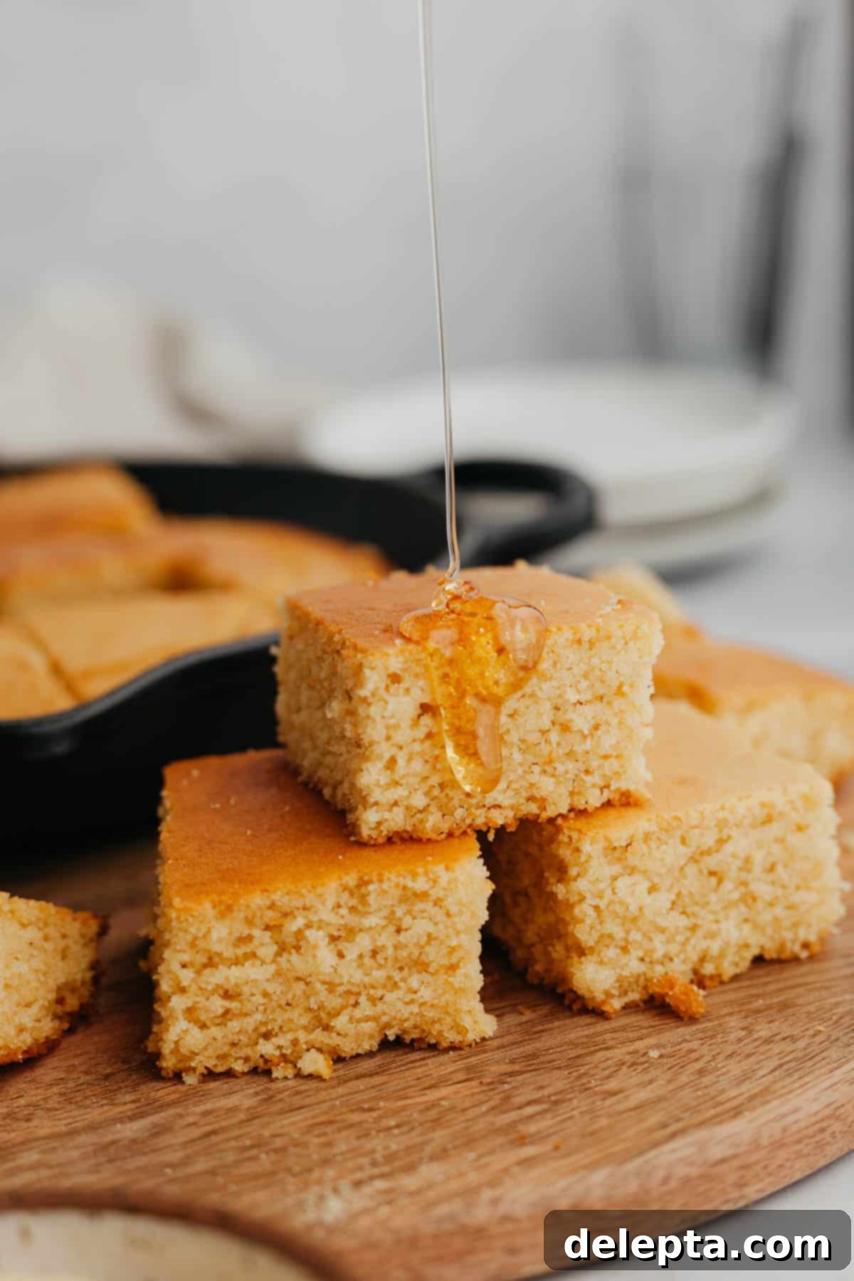 Pantry Staple Cornbread 2 Golden brown cornbread loaf with a crispy crust in a cast iron skillet