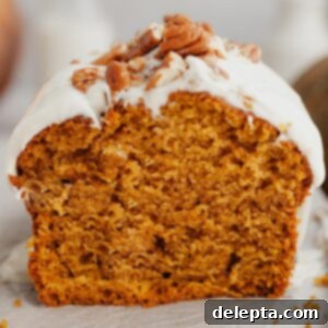 Velvet Pumpkin Loaf with Rich Cream Cheese Frosting 10 A perfect slice of moist pumpkin bread generously covered with fluffy cream cheese frosting and a sprinkle of chopped pecans.
