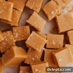 Effortless Peanut Butter Dream 8 A pile of peanut butter fudge squares, glistening and perfectly cut.