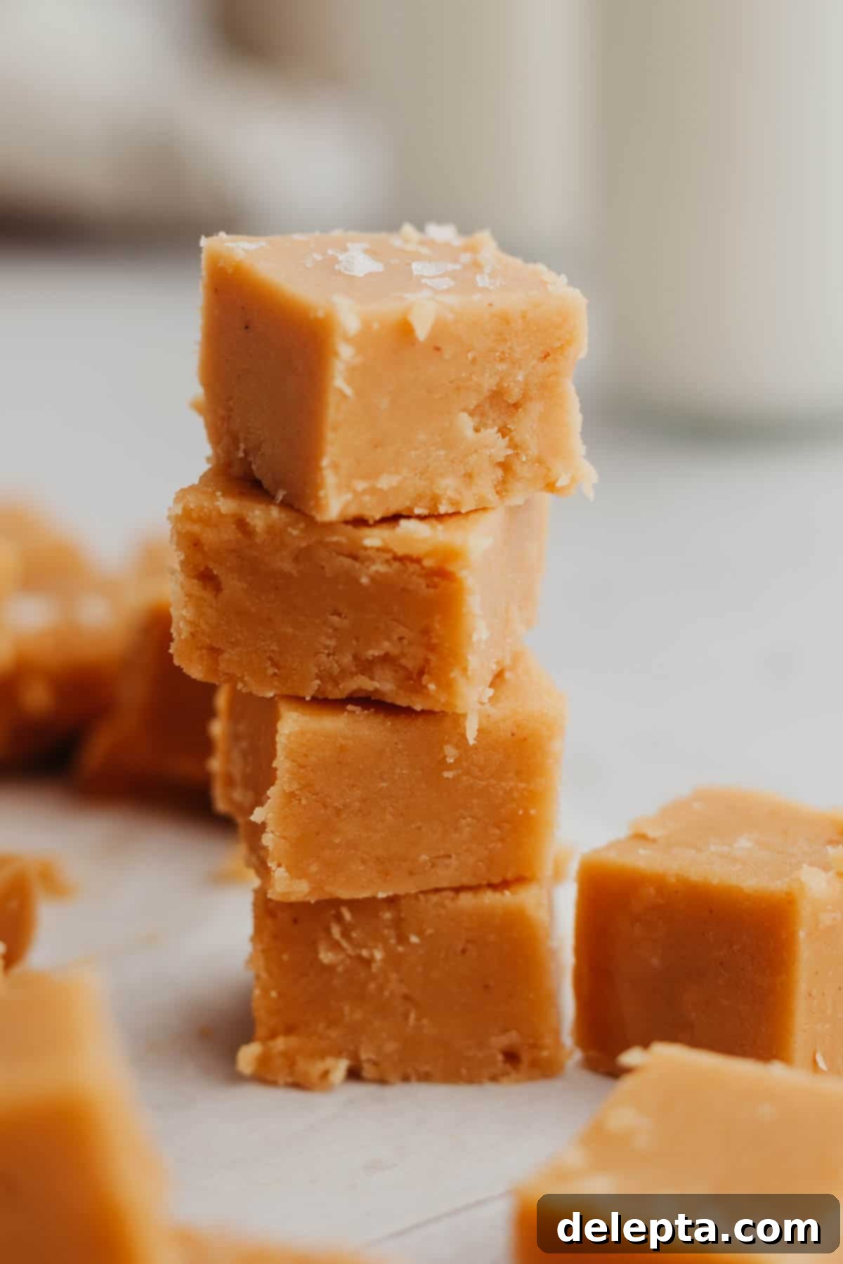 Effortless Peanut Butter Dream 7 A perfectly arranged stack of four delightful pieces of homemade no-bake peanut butter fudge, showcasing their smooth, inviting texture and golden color.
