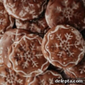 Old World German Gingerbread 9 A festive pile of soft German gingerbread cookies, each beautifully stamped with a snowflake design and glazed, perfect for the holidays.