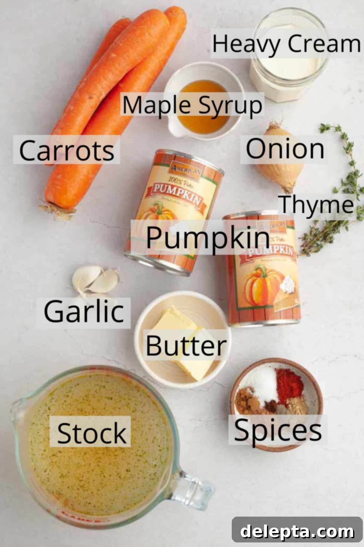 Velvet Pumpkin Carrot Soup 3 All the fresh and canned ingredients meticulously arranged on a white marble counter, ready for making pumpkin carrot soup.