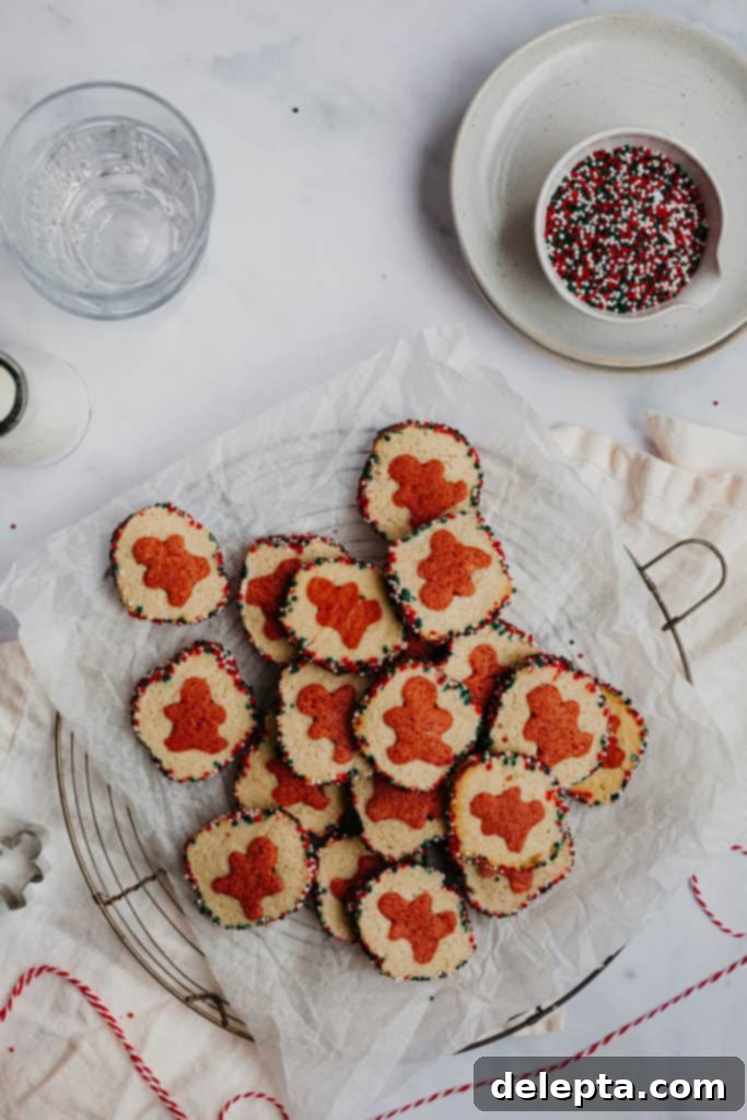 Effortless Holiday Cookie Bliss 2 pile of slice and bake cookies on parchment paper, with a bowl of sprinkles