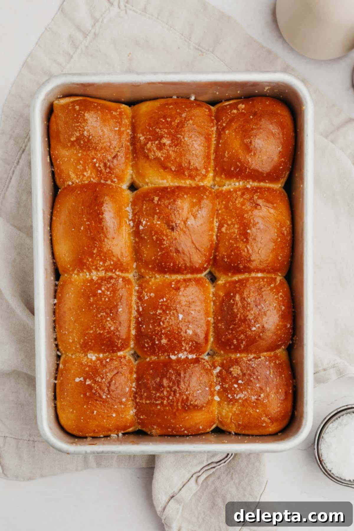 Soft Brioche Dinner Rolls 7 Baked brioche dinner rolls in a rectangular pan.