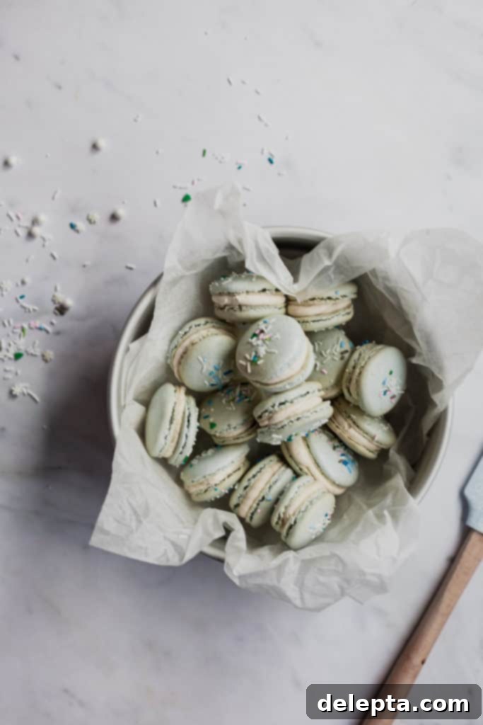 Eggnog Bliss Macarons 3 tin full of eggnog macarons with sprinkles on top