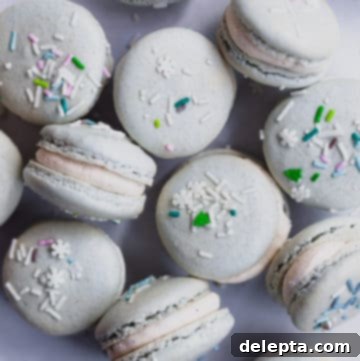 Eggnog Bliss Macarons 5 tin full of eggnog macarons with sprinkles on top