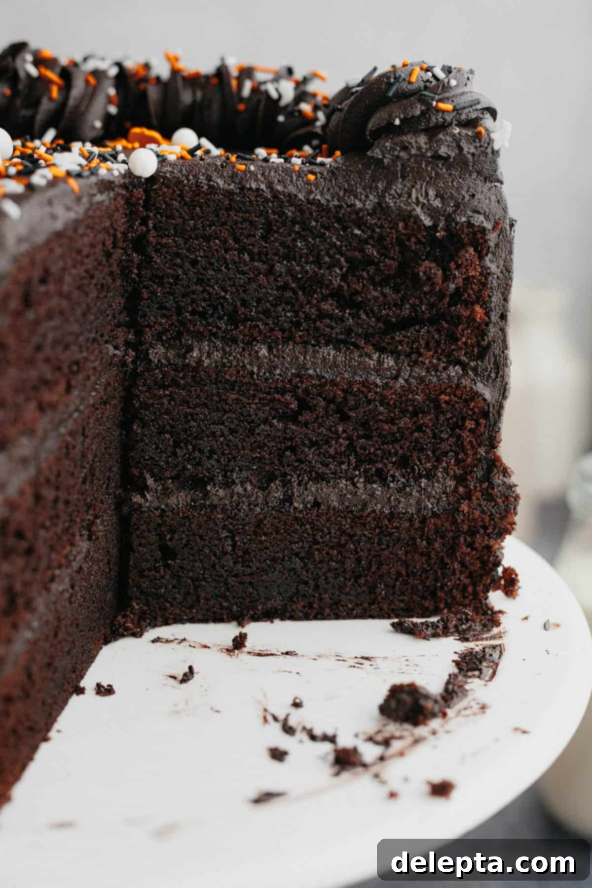 Midnight Velvet Indulgence 2 A three layer black velvet cake, sliced on a white cake stand.