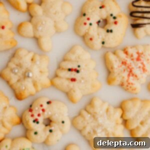 Velvet Cream Cheese Spritz Delights 8 Spritz cookies decorated with sprinkles on marble.