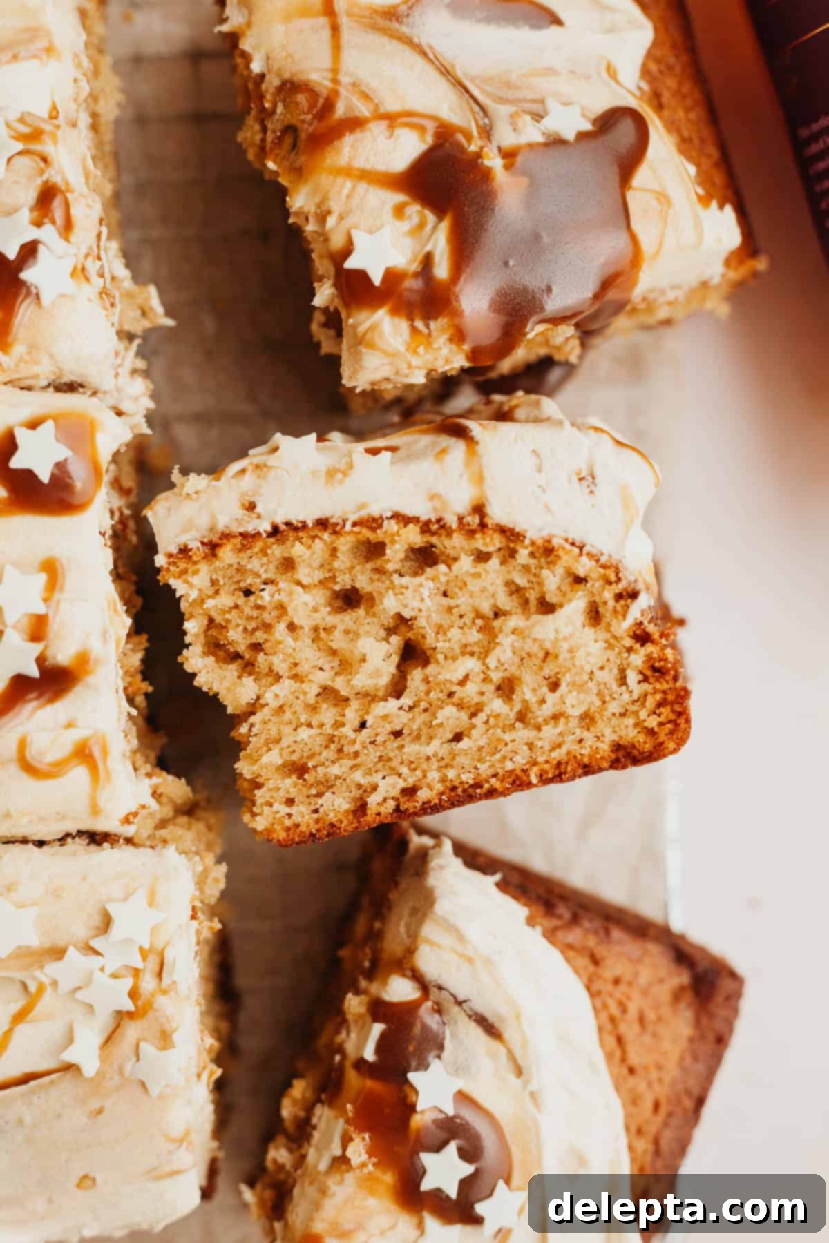 Golden Butterscotch Dream 9 Several square slices of moist butterscotch cake arranged on parchment paper, with one slice charmingly turned on its side to reveal its tender crumb.