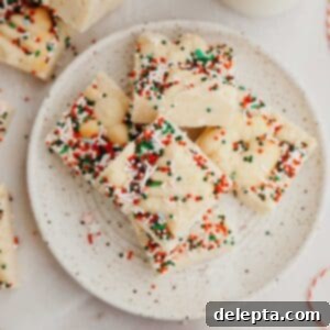 Festive Christmas Cookie Fudge 8 A small plate with perfectly cut pieces of Christmas cookie fudge, garnished with festive sprinkles and mini cookies, a delightful holiday treat.