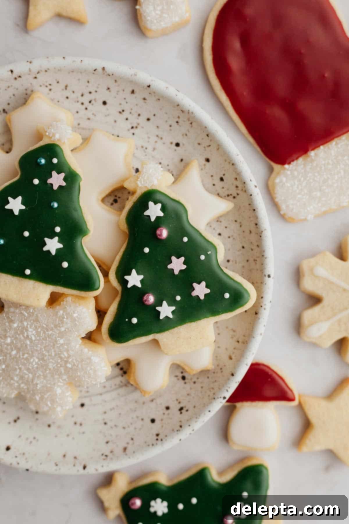 Flawless Cut-Out Sugar Cookies 2 A small plate with beautifully decorated Christmas cookies, featuring icing and festive sprinkles.