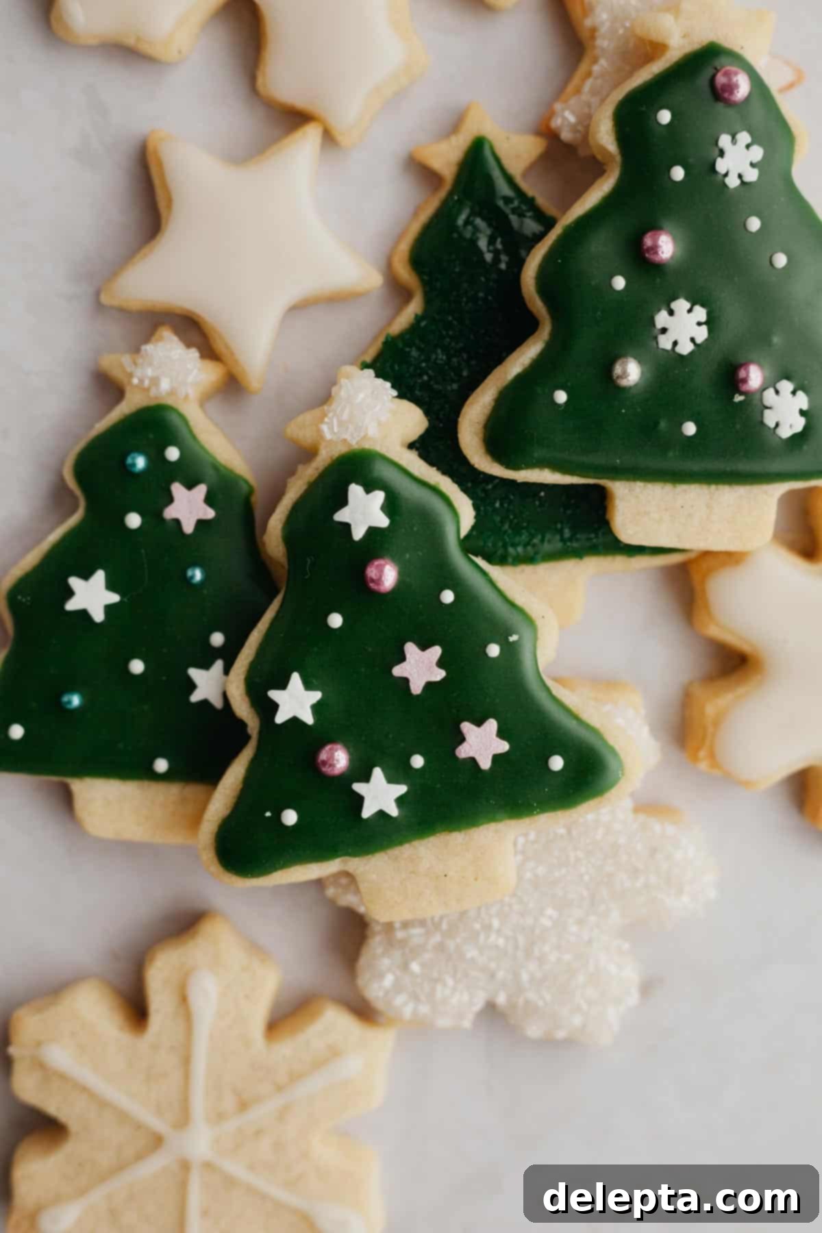 Flawless Cut-Out Sugar Cookies 9 A small pile of perfectly cut out and baked sugar cookies in the shape of Christmas trees, awaiting decoration.