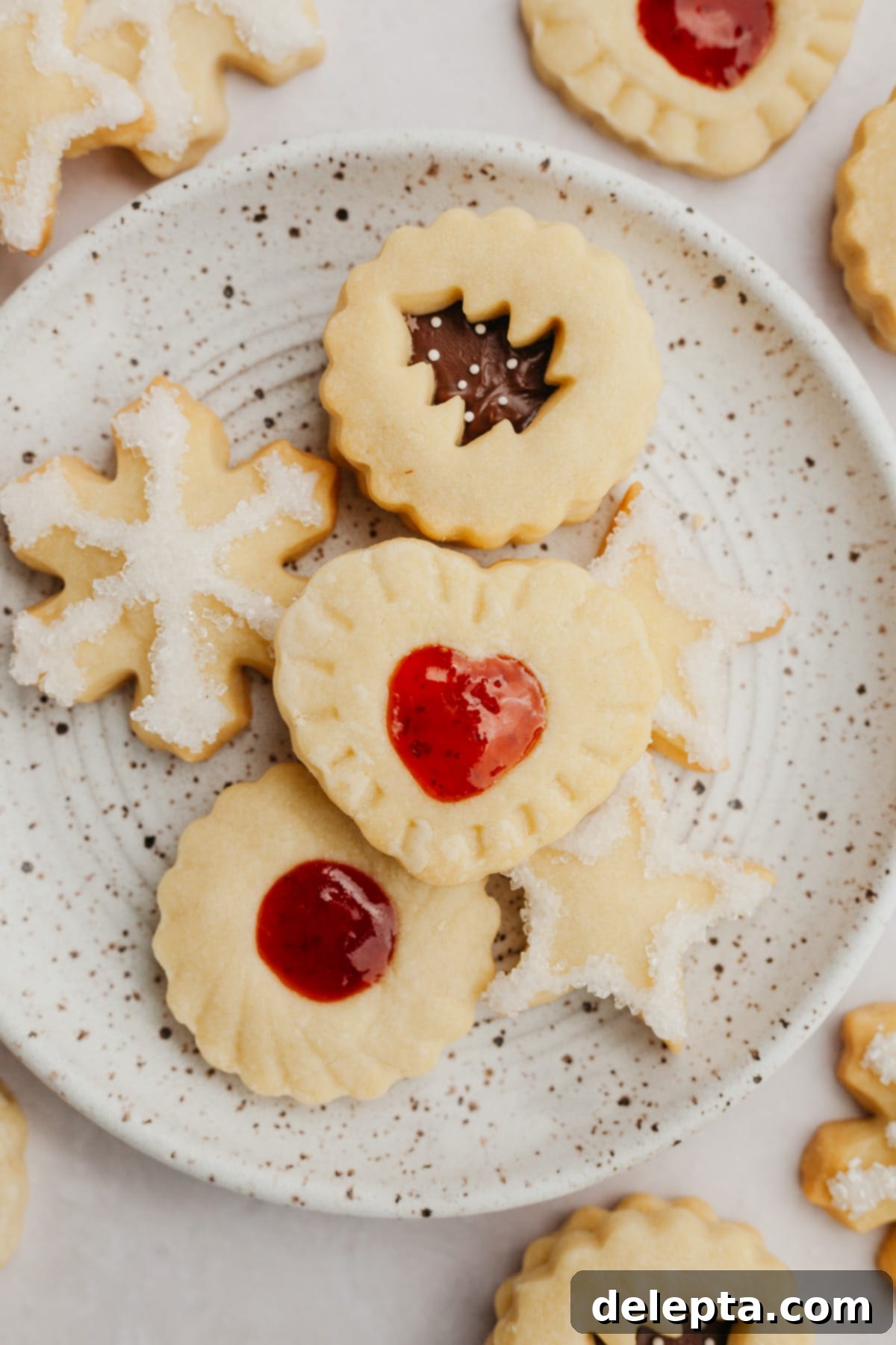 Foolproof Cutout Shortbread Cookies 8 Another view of a small plate artfully arranged with various shapes of shortbread cookies, showcasing their golden edges and perfect form.