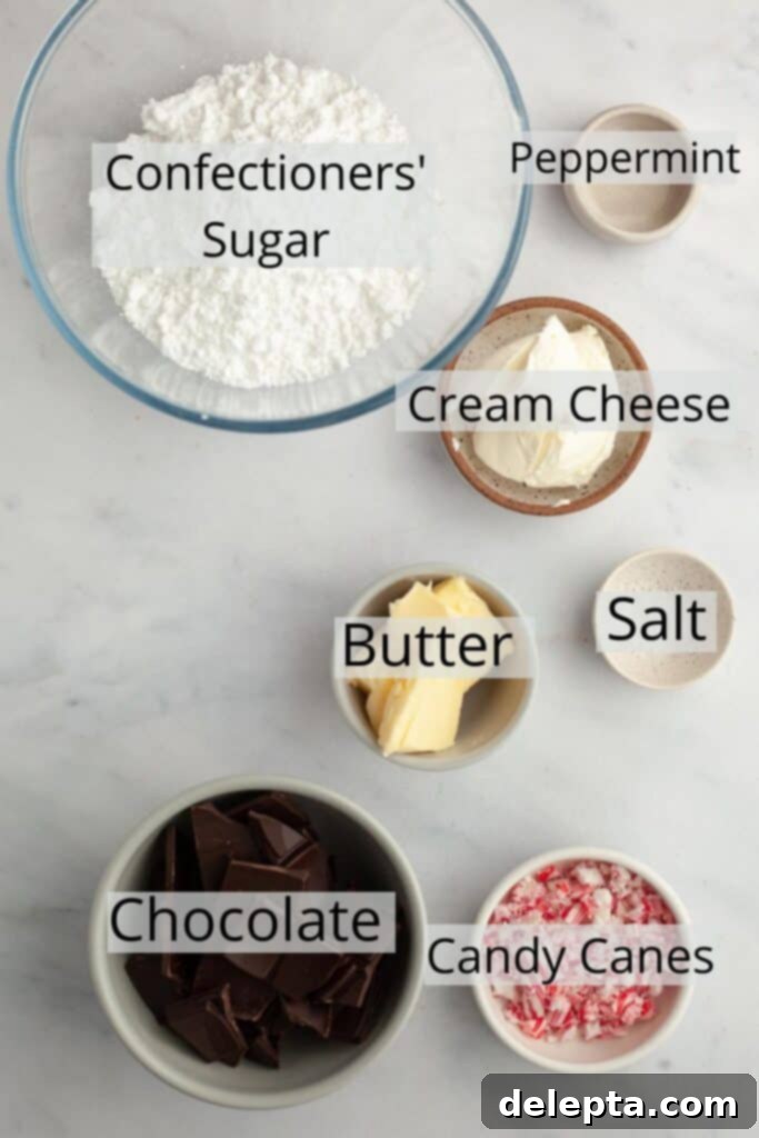 Peppermint Bark Fudge Squares 4 The full spread of ingredients required for making peppermint bark brownies, including chocolate, butter, sugars, cream cheese, peppermint extract, and crushed candy canes.