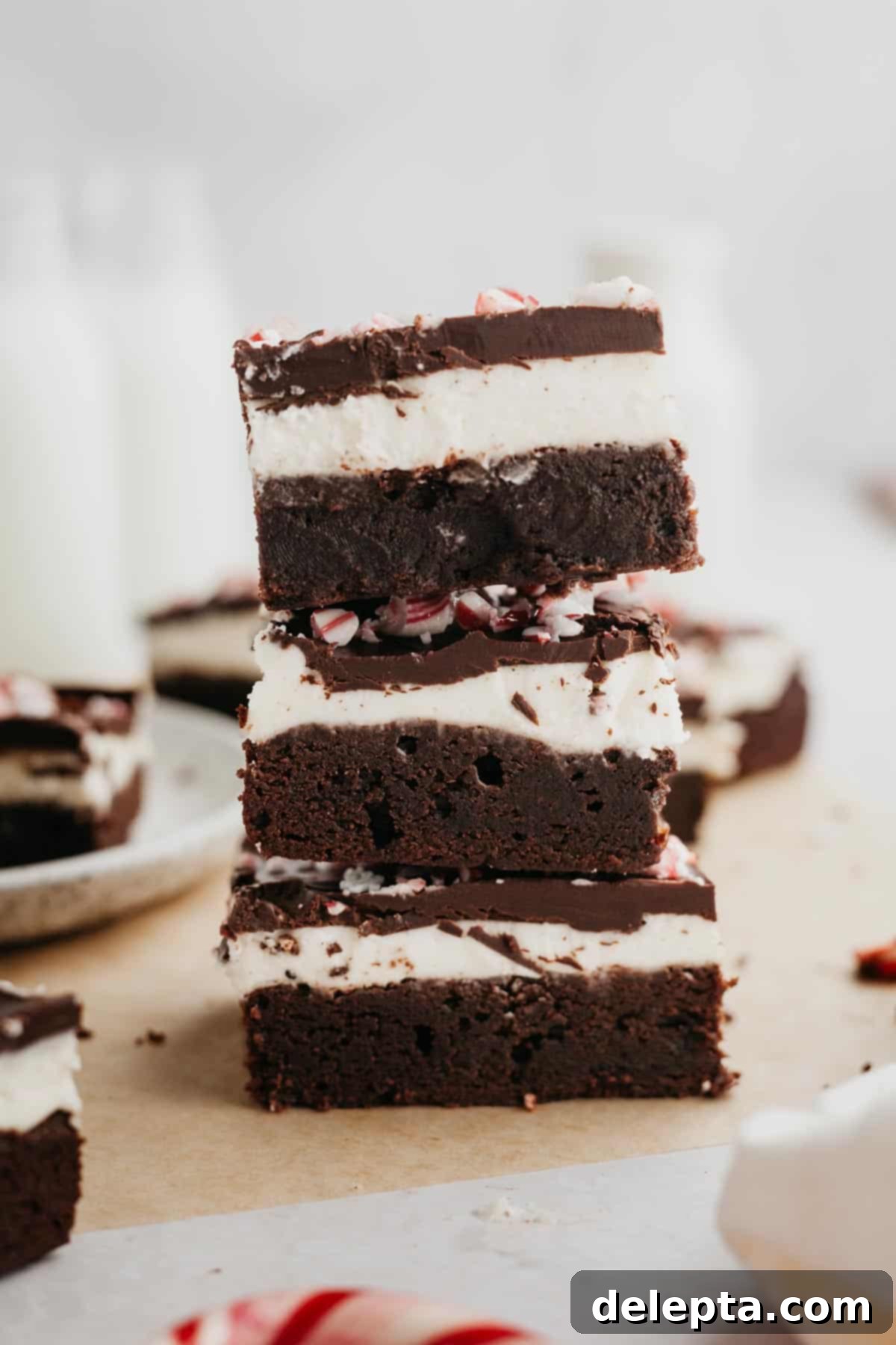 Peppermint Bark Fudge Squares 9 A perfectly stacked trio of peppermint bark brownies, showing off their distinct and delectable layers, ready to be enjoyed.