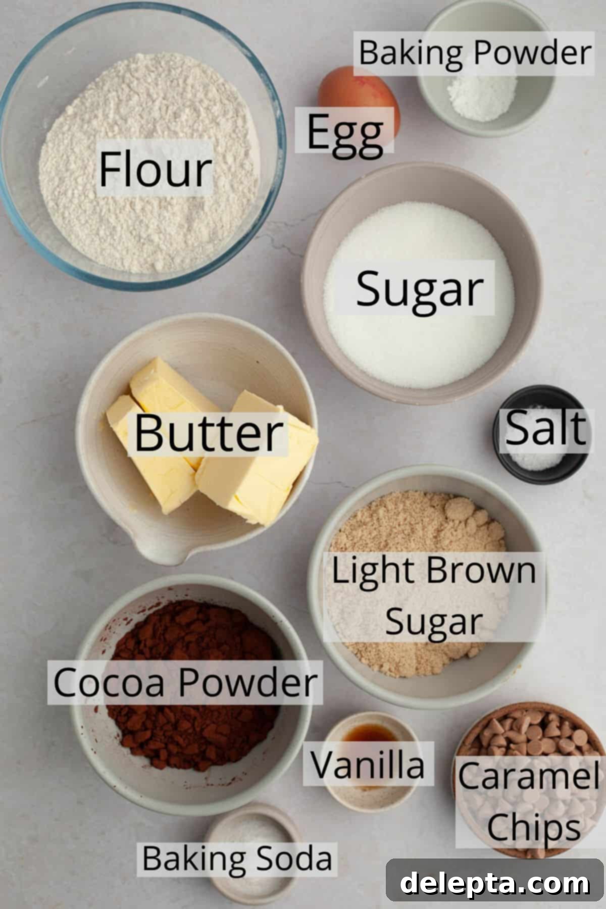 Decadent Caramel Chocolate Cookies 3 All the necessary ingredients to bake homemade chocolate caramel cookies, meticulously weighed out and arranged in small bowls on a kitchen counter.