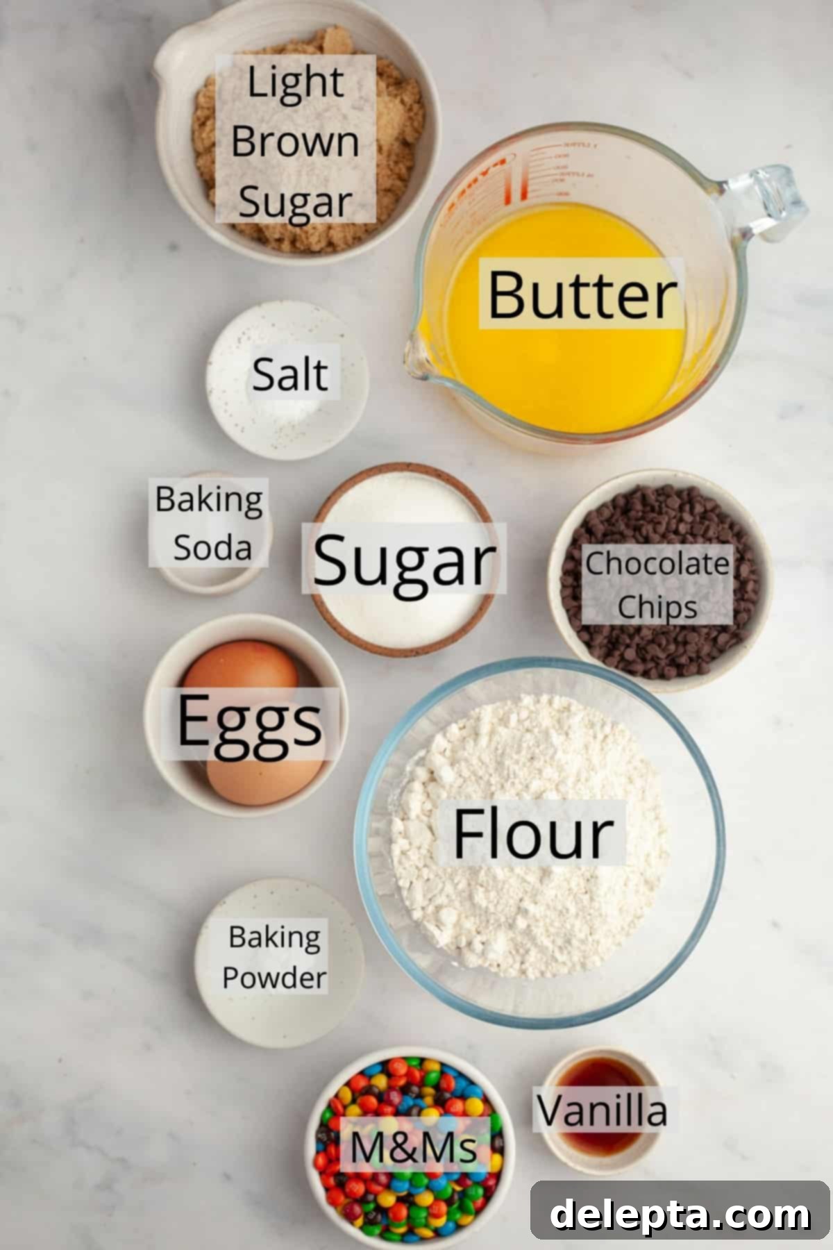 One-Bowl Rainbow Chip Cookie Delight 3 A collection of ingredients for M&M chocolate chip cookies, including flour, sugars, M&Ms, and chocolate chips.