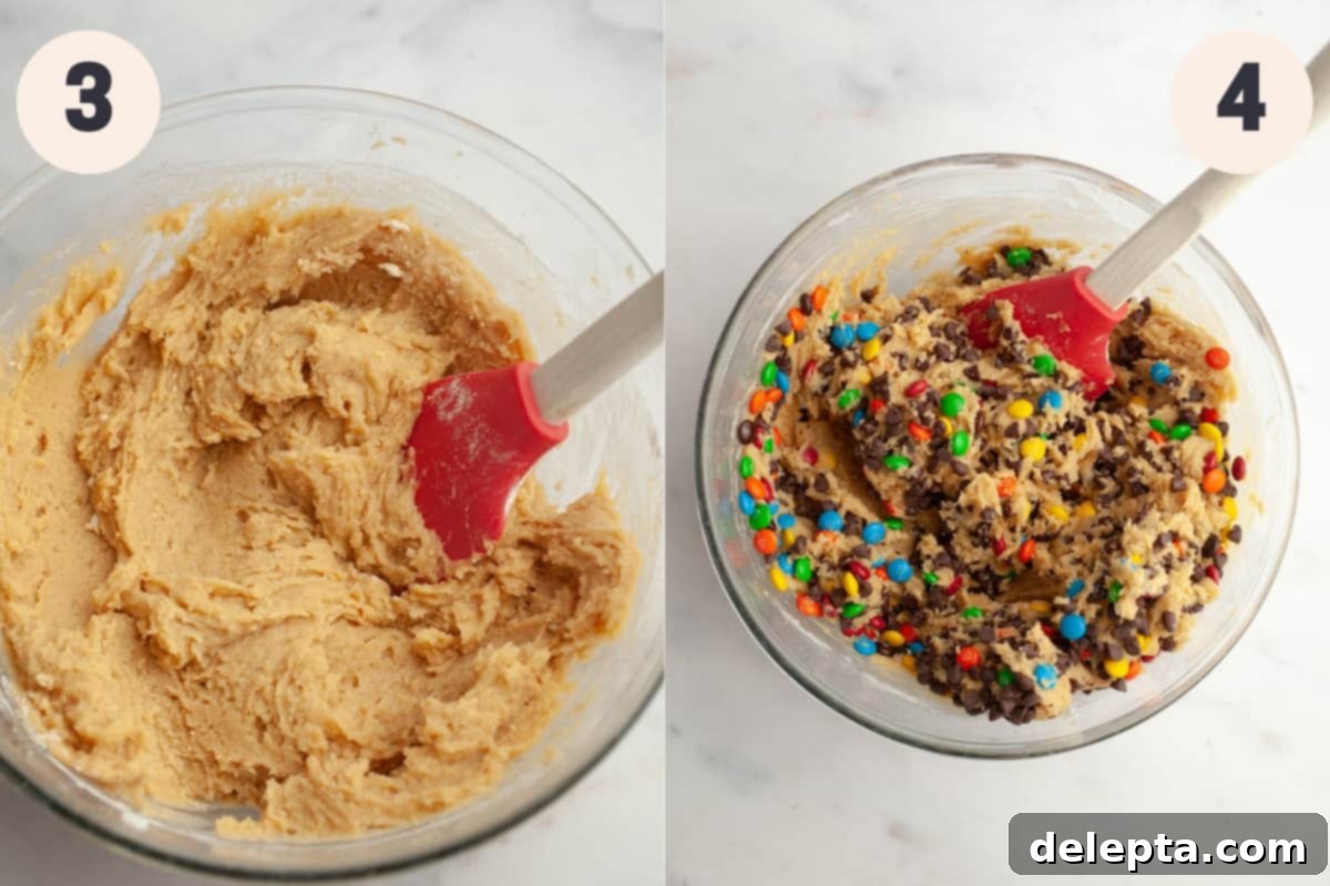 One-Bowl Rainbow Chip Cookie Delight 5 A glass bowl with M&M chocolate chip cookie dough and a rubber spatula, showing the dry ingredients being folded in.