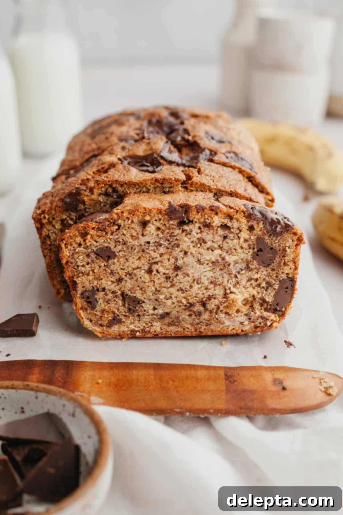 Seriously Moist Chocolate Chunk Banana Bread 9 A freshly baked and sliced banana bread loaf with visible chocolate chunks, ready to be served.