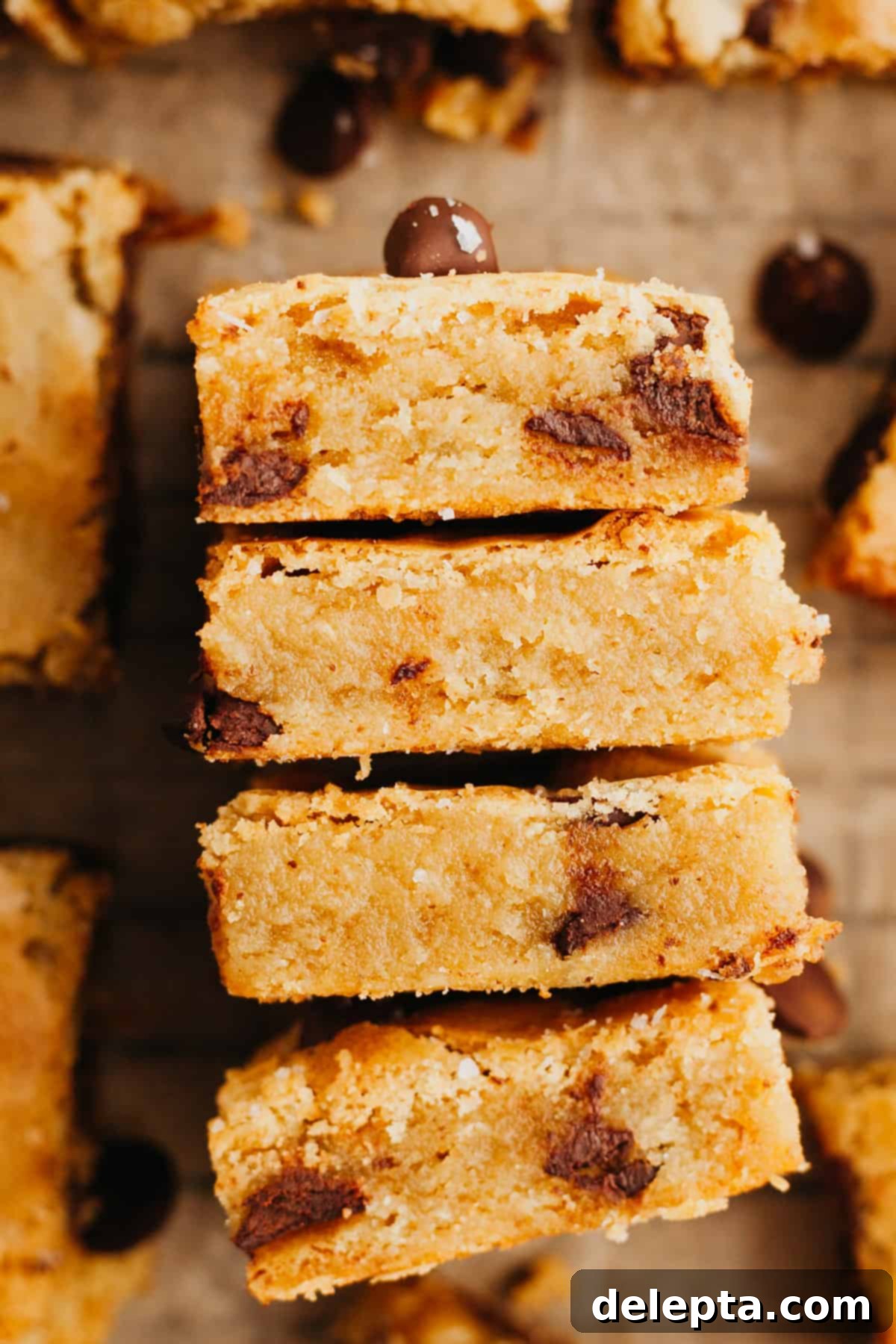 Caramelized Brown Butter Blondies Simple Perfection 7 Four perfectly baked chocolate chip blondies stacked on their sides, showcasing their thick, fudgy texture.