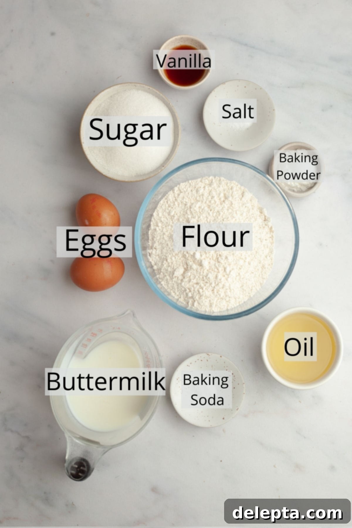 Bakery Style Moist Vanilla Muffins 3 All the essential ingredients neatly arranged on a counter, ready to make vanilla muffins.