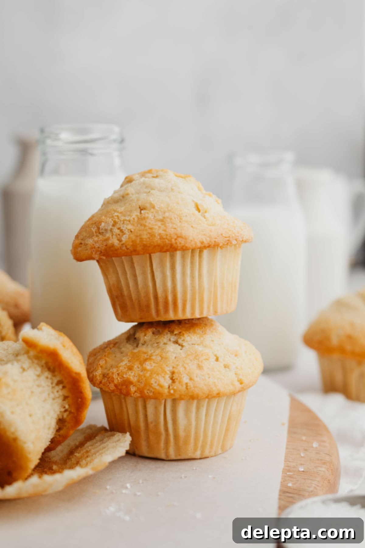 Bakery Style Moist Vanilla Muffins 7 A beautiful stack of two golden-brown vanilla muffins, showcasing their fluffy texture.