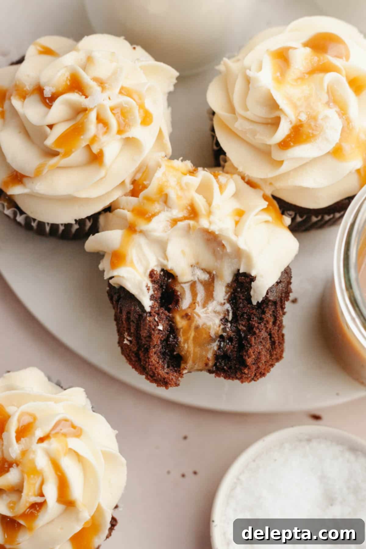 Decadent Chocolate Salted Caramel Cupcakes 11 A delectable chocolate cupcake with a visible caramel filling, a bite taken out to reveal the moist cake and gooey center.