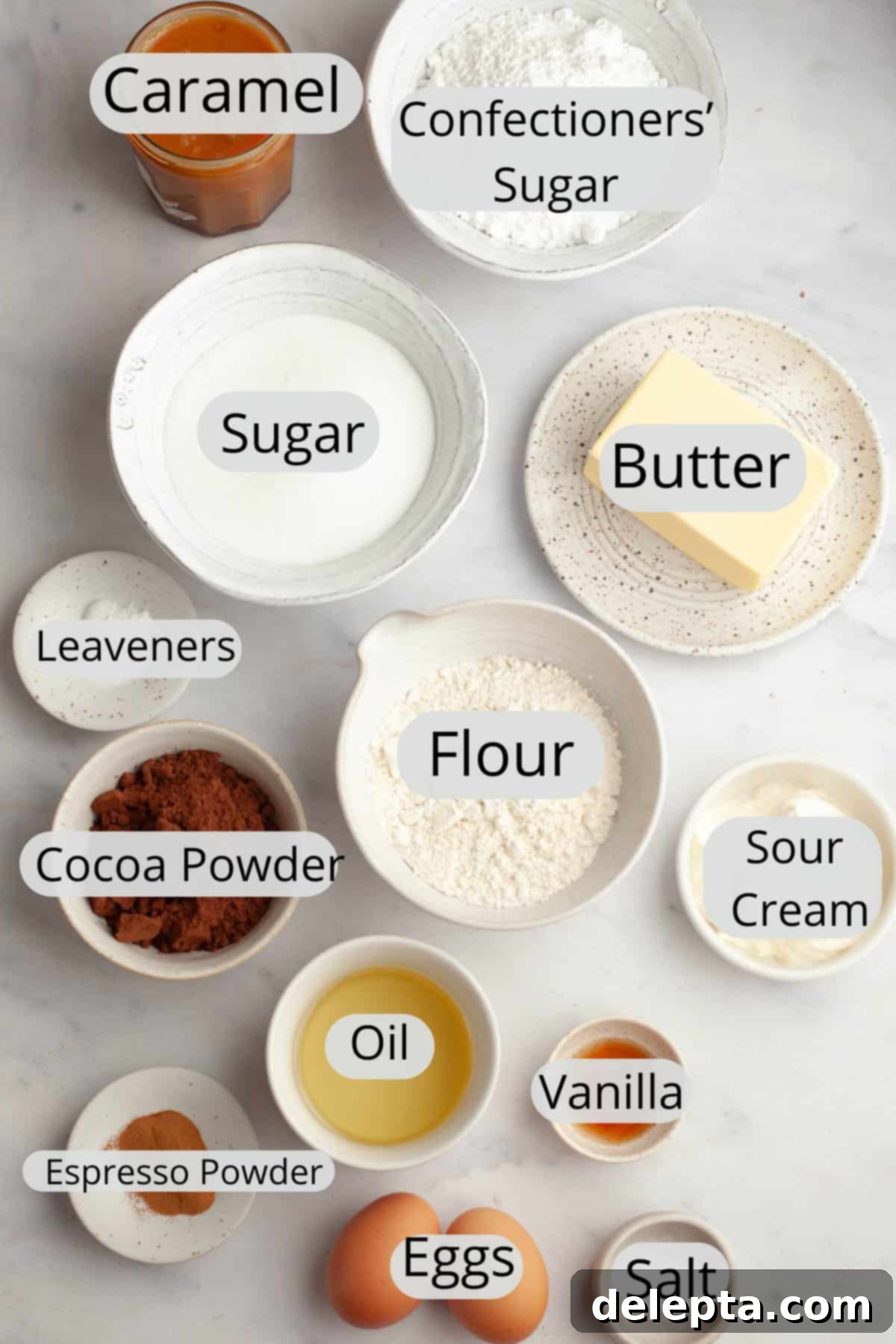 Decadent Chocolate Salted Caramel Cupcakes 3 All the ingredients needed to make chocolate caramel cupcakes, carefully weighed out into small bowls, displayed on a clean surface.