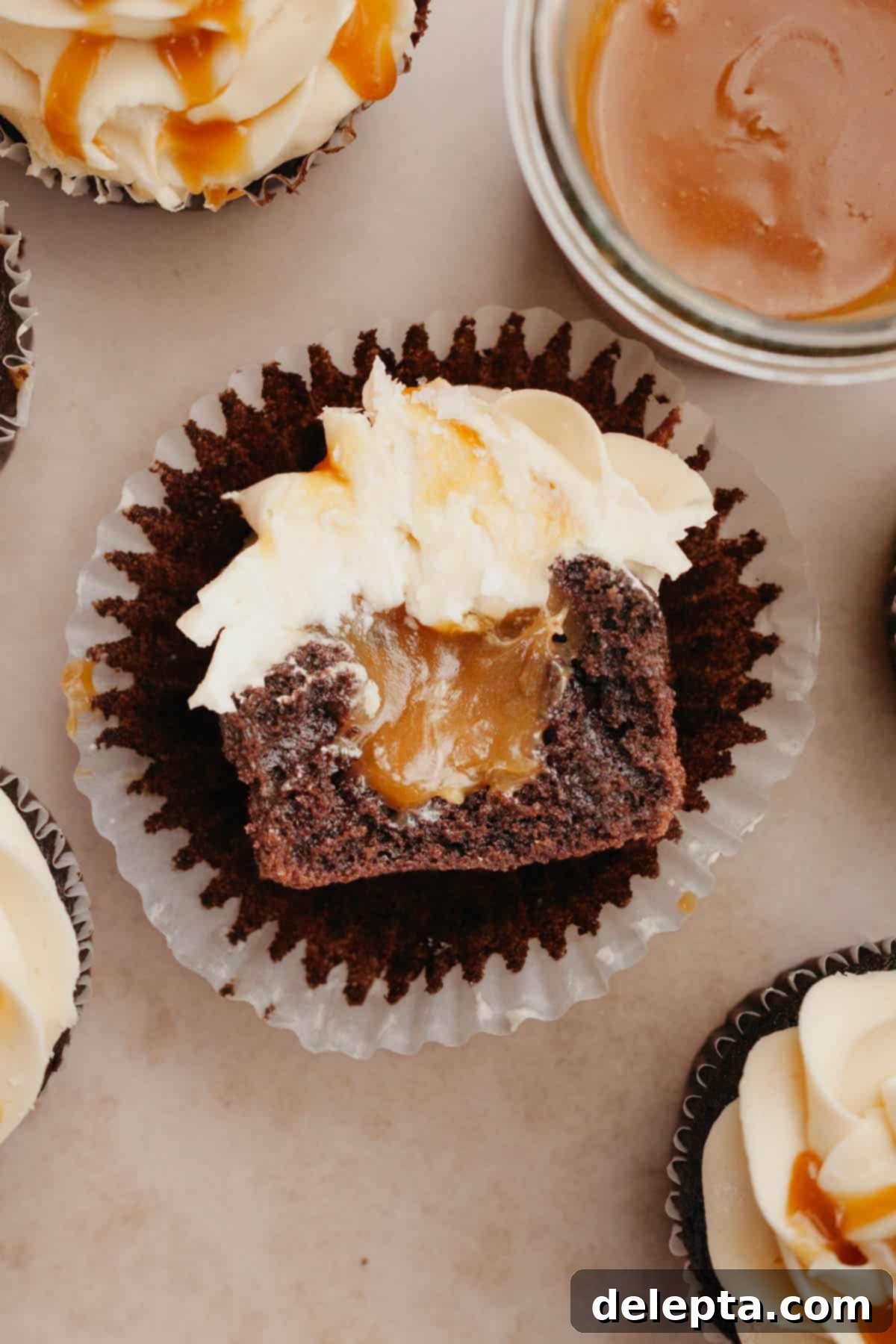 Decadent Chocolate Salted Caramel Cupcakes 10 A perfectly baked chocolate cupcake with a gooey salted caramel filling, cut in half to show the delicious interior.