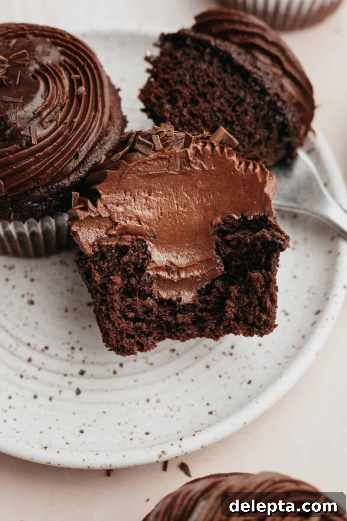 Decadent Chocolate Fudge Cupcakes 2 A chocolate cupcake sliced in half, showing a chocolate filling.