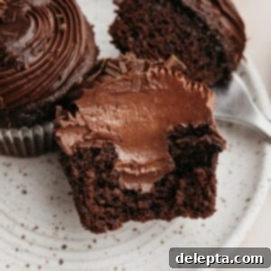 Decadent Chocolate Fudge Cupcakes 11 A chocolate cupcake sliced in half, showing a chocolate filling.