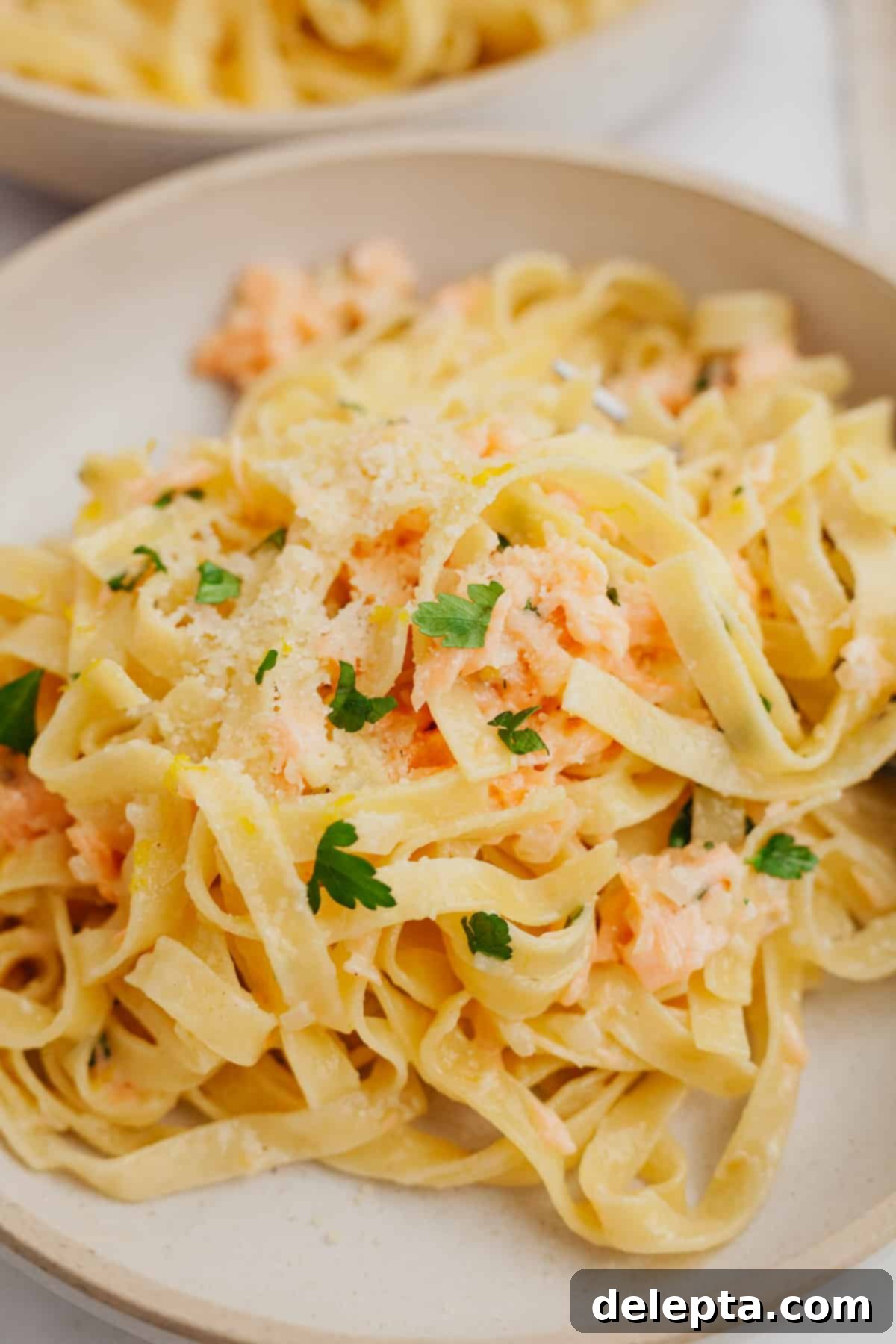 Creamy Salmon Pasta with Crème Fraîche 2 A bowl full of pasta with chopped parsley and salmon, ready to be served.