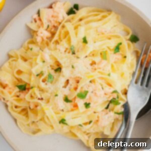 Creamy Salmon Pasta with Crème Fraîche 8 A bowl full of pasta with chopped parsley and salmon.