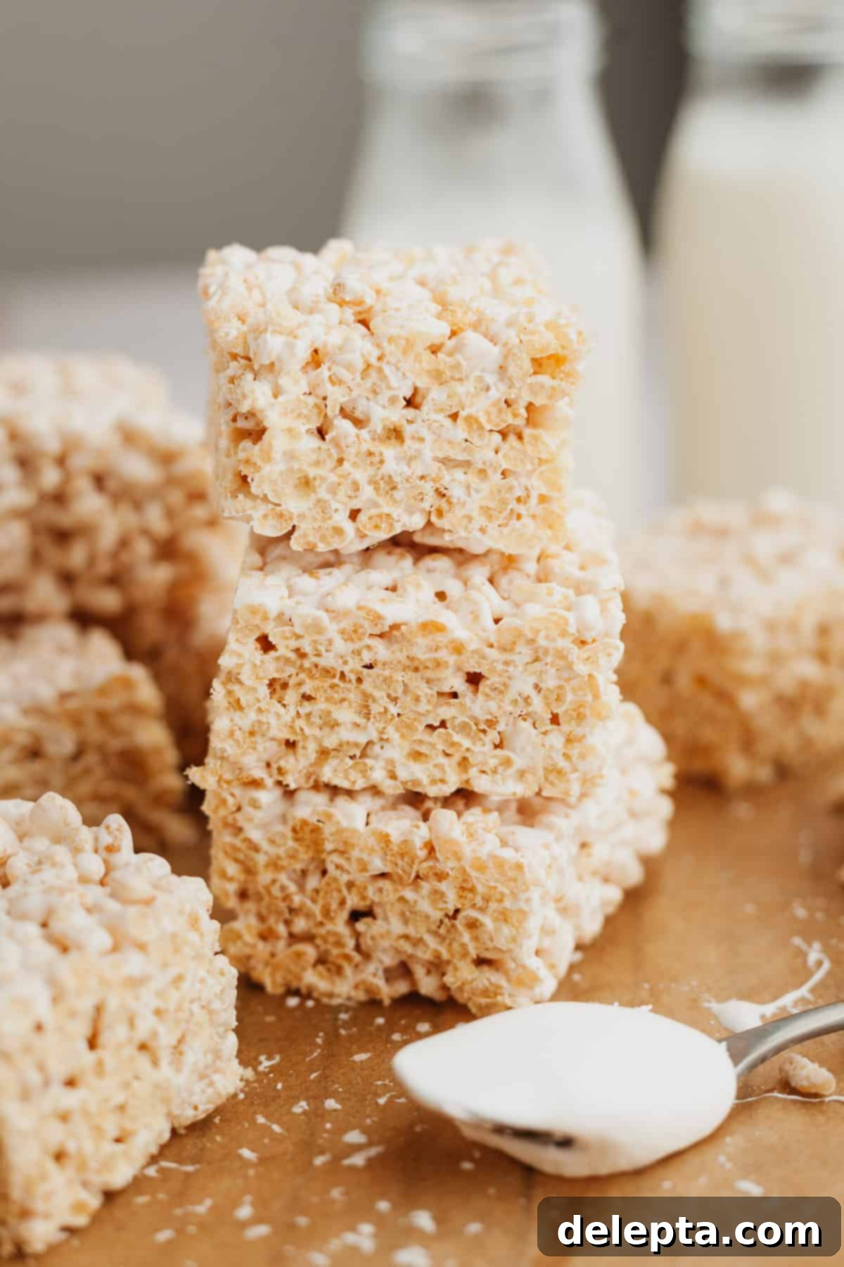 Fluffy Marshmallow Krispie Bars 2 A stack of three perfectly golden brown butter marshmallow fluff rice krispie treats, showcasing their delightful texture.