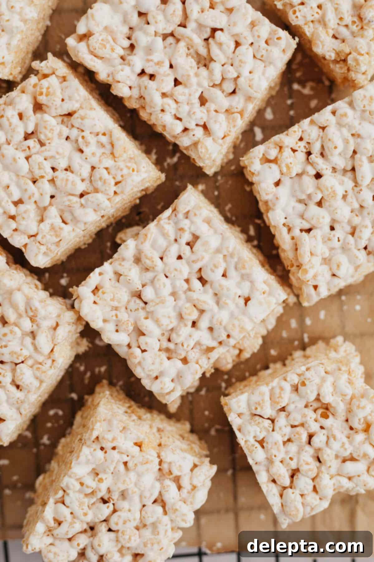 Fluffy Marshmallow Krispie Bars 6 Freshly made rice krispie treats with marshmallow fluff cooling on a wire rack.