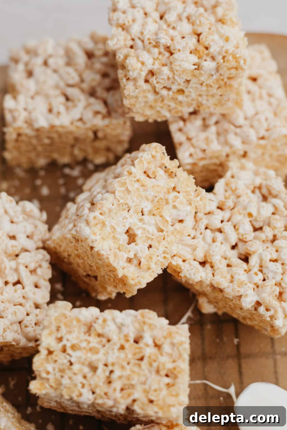 Fluffy Marshmallow Krispie Bars 7 Close-up of rice krispie treats made with marshmallow fluff on a wire rack, ready for storage.