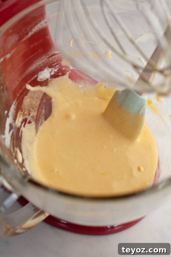 Aşağıdaki başlığı İngilizce'ye çevir ve özgünleştir: Black Forest Yule Log (Bûche de Nöel) Dark Chocolate Cherry Yule Log 5 A glass stand mixer bowl with a pale yellow batter, showing the richness and smoothness of the egg yolk mixture.