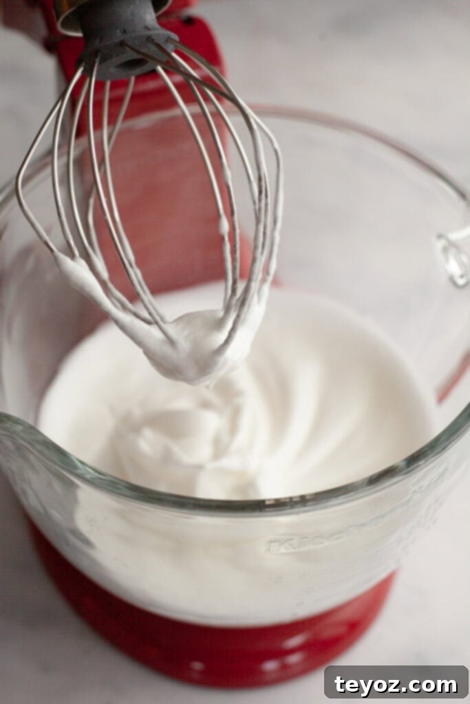 Chocolate Peppermint Dream Yule Log 4 A vibrant red stand mixer with a clear glass bowl, showcasing perfectly whipped meringue.