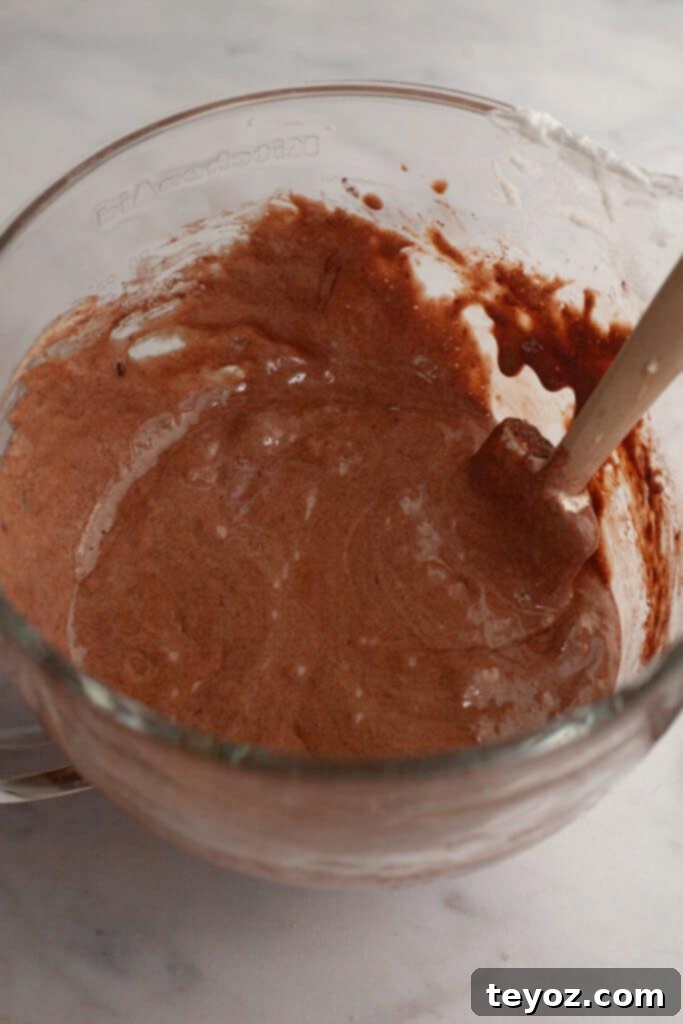 Chocolate Peppermint Dream Yule Log 6 A clear glass mixing bowl filled with a smooth, rich chocolate cake batter, ready for baking.