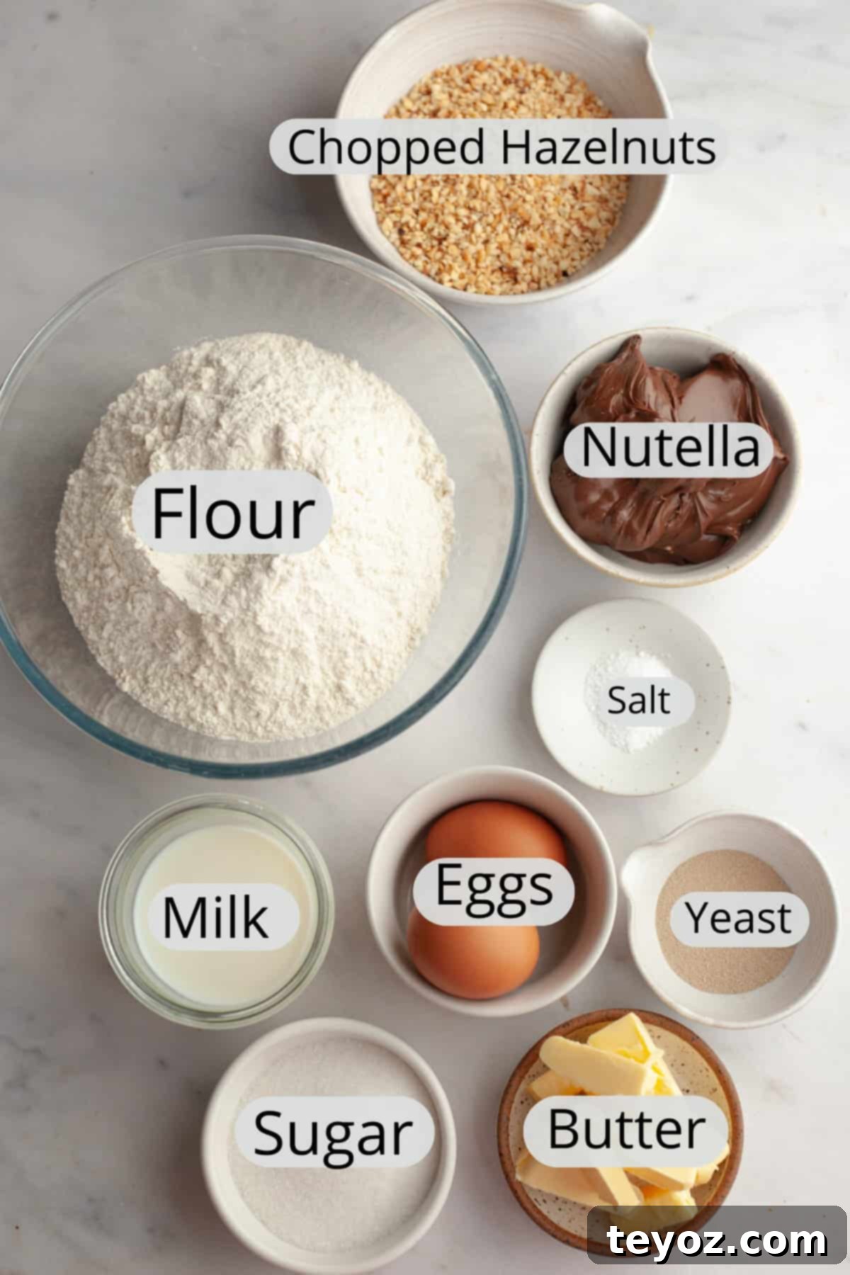 A visually appealing arrangement of all the necessary ingredients for making Nutella cinnamon rolls, neatly weighed out into individual small bowls for easy preparation.